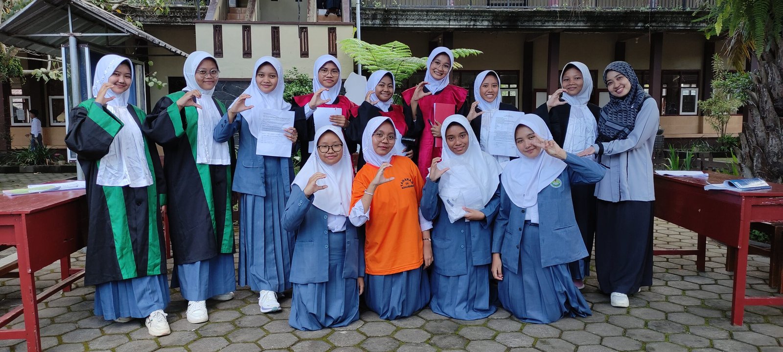 Siswa SMP Bustanul Makmur mengenakan atribut persidangan saat melakukan simulasi dalam uji praktik Pendidikan Pancasila di kelas dan halaman sekolah.
